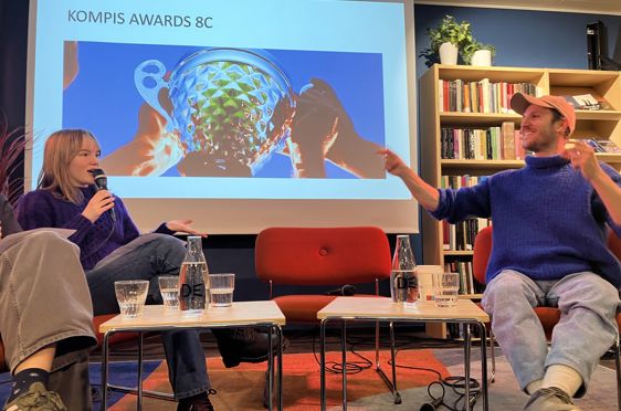 En person og en person som sitter foran en skjerm