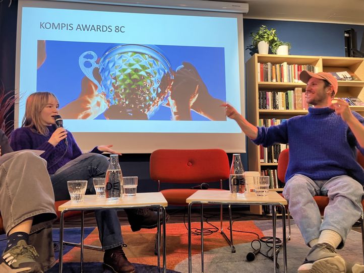 En person og en person som sitter foran en skjerm