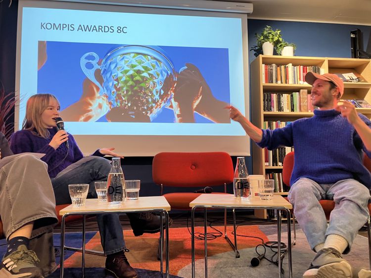 En person og en person som sitter foran en skjerm