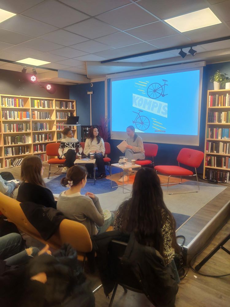 en gruppe mennesker som sitter i et bibliotek